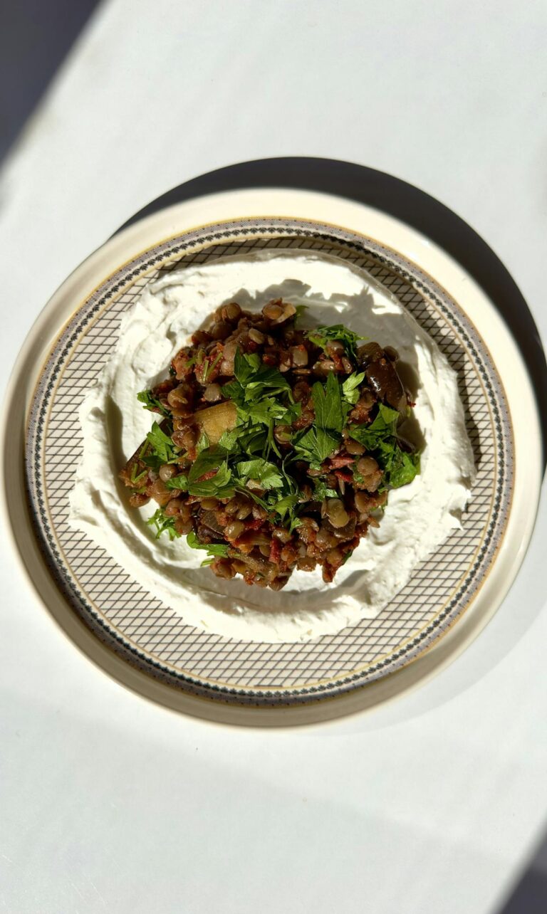 Vibrant vegetarian dish garnished with fresh herbs on creamy sauce.